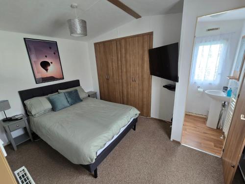a bedroom with a bed and a television in it at B17 Sunnymede Caravan Park, Fantasy Island, Ingoldmells in Ingoldmells