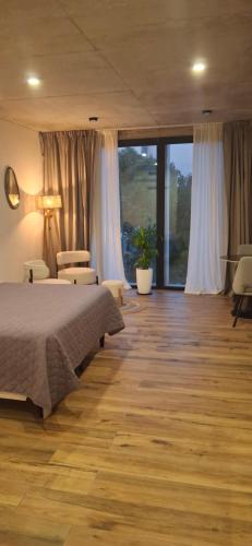 a bedroom with a bed and a large window at Depto Zona Güemes Mdp in Mar del Plata