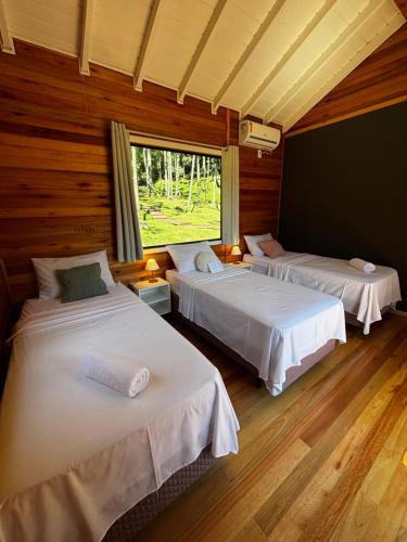 a bedroom with two beds and a window at Quinta Terra Sagrada in Urubici