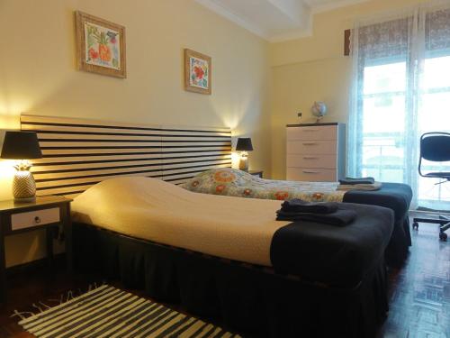 a bedroom with two beds and a dresser at Luz de Cacilhas Apt, few steps away from Lisboa! in Almada
