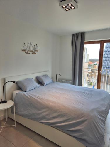 a bedroom with a large bed and a window at Alpha 503 in De Panne