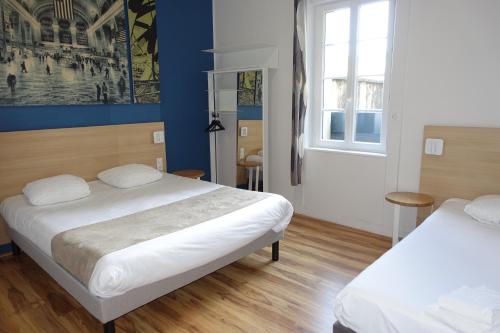 two beds in a room with blue walls at Hôtel de la Gare - Restaurant Bistro Quai in La Roche-sur-Yon