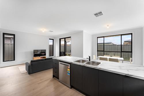eine Küche mit Spüle und ein Wohnzimmer in der Unterkunft Stylish Luxury 4BR - Close to Wineries & City in Munno para Downs