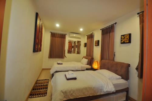 une chambre d'hôtel avec deux lits et une chaise dans l'établissement 4 BR Pool Villa Hua Hin Blue Lagoon, à Cha Am