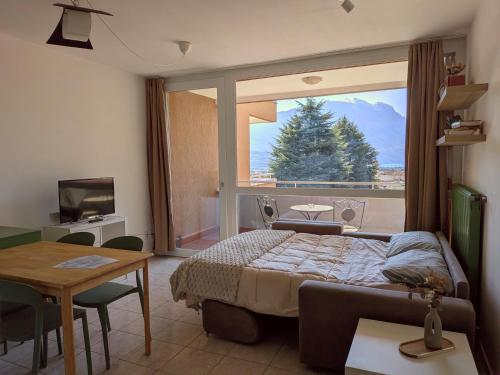 a bedroom with a bed and a large window at Green Oasis Garda Apartment in Riva del Garda