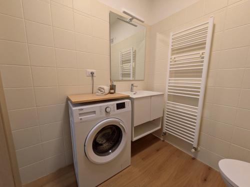 a bathroom with a washing machine and a sink at Green Oasis Garda Apartment in Riva del Garda