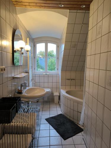 a bathroom with a tub and a sink at Baroque Palais Timber House Celle in Celle