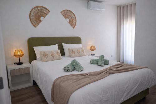a bedroom with a large white bed with pillows at The Douro Nest in Valença do Douro