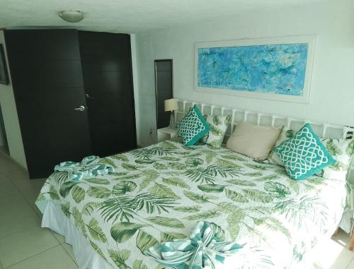 a bedroom with a large bed with blue pillows at Acapulco, gro Casi el Cielo in Acapulco
