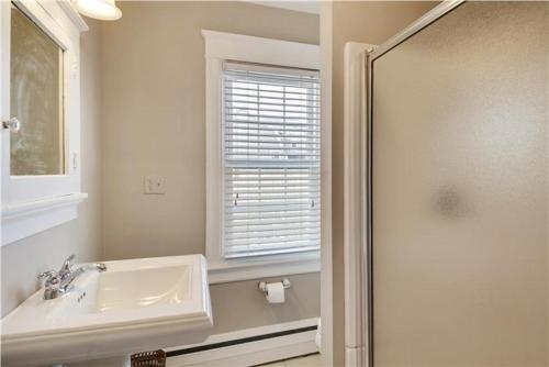 a bathroom with a sink and a window and a shower at The Cape May Diamond in Cape May