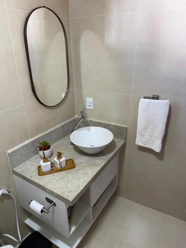 a bathroom with a sink and a mirror at Suite LUAR in Saquarema