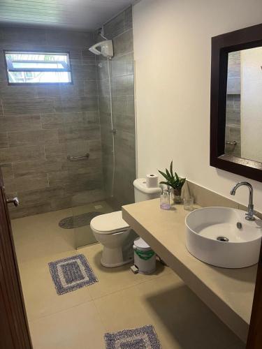 a bathroom with a toilet and a sink and a shower at Pousada Casa da Praticagem in Salinópolis