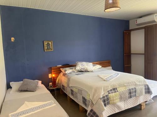 a bedroom with two beds and a blue wall at Pousada Casa da Praticagem in Salinópolis