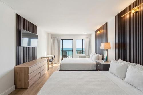 a hotel room with a bed and a large window at Grande Beach Resort in Myrtle Beach
