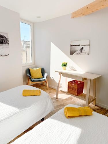 two beds in a room with a desk and a chair at L'Appart du Faubourg 1 à 8 Personnes in Valence