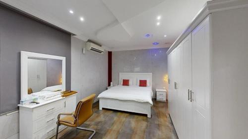 a bedroom with a bed and a desk and a chair at Happiness Farm in Hatta