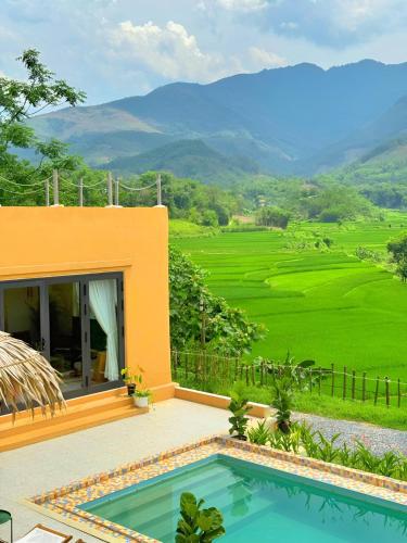 a villa with a pool and a view of a field at Campo De Sole Villa Hoa Binh in Hòa Bình