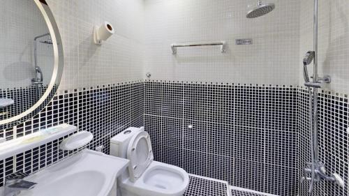 a bathroom with a toilet and a sink and a mirror at Happiness Farm in Hatta
