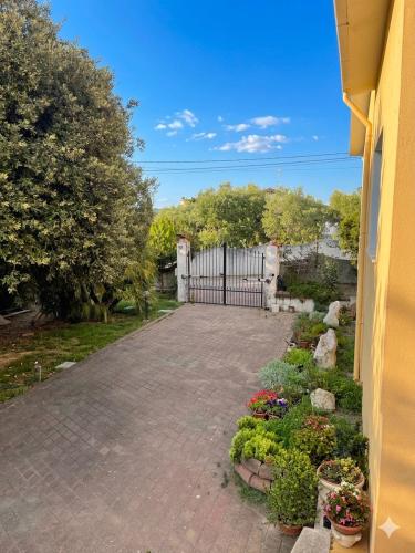 a driveway with a gate and flowers in a yard at Prenda e Mare in Ottava Sassari