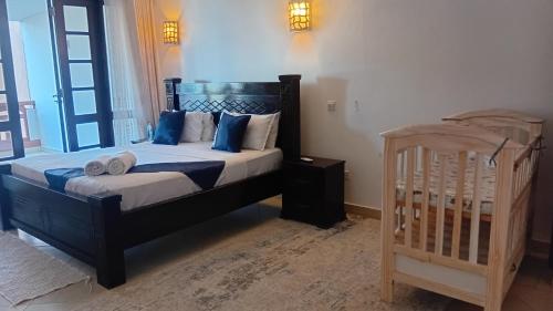 a bedroom with a bed and a crib in it at Palm breeze seafront shanzu in Shanzu