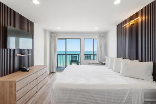 a bedroom with a large bed and a large window at Grande Beach Resort in Myrtle Beach
