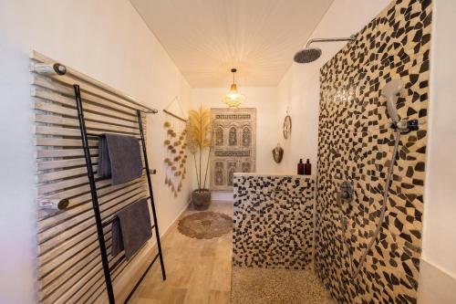 a bathroom with a walk in shower next to a door at 3BDR Villa with Pool Jacuzzi - Canggu in Dalung