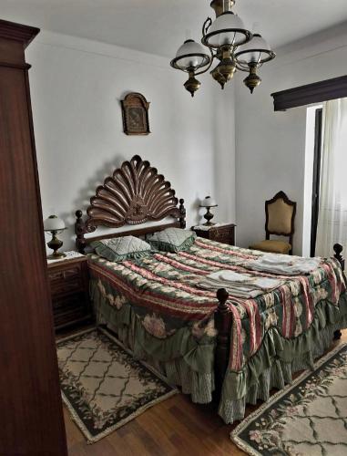 a bedroom with a large bed with a wooden headboard at Aurélio & Zezinha House in Penamacor