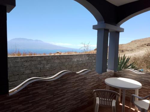 a patio with a table and chairs and a wall at Djabraba's space in Garça