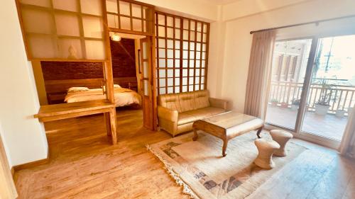a bedroom with a bed and a chair and a window at Circle of Life in Baudhatinchule