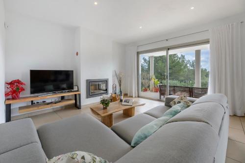 a living room with a couch and a tv at Villa Es Redo-Spacious & Relax in Sant Josep de sa Talaia