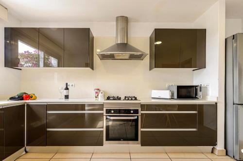 a kitchen with brown cabinets and a stove top oven at Villa Es Redo-Spacious & Relax in Sant Josep de sa Talaia