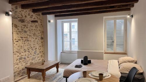 a room with two beds and a table and two windows at Le Chêne Doré in Bellac