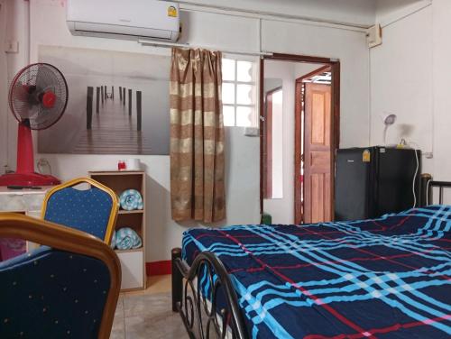 a bedroom with a bed and a fan at BEN & LEK GUESTHOUSE in Pattaya South
