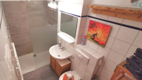 a bathroom with a sink and a toilet and a mirror at Ferienwohnung Wellenreiter 200 m zum Strand Fewo strandnah mit Balkon Parkplatz Wlan in Karlshagen