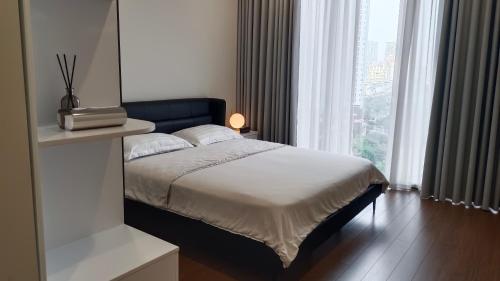 a bedroom with a bed and a large window at Full House - The Matrix One in Hanoi