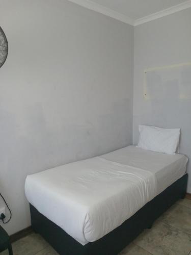 a bed in a room with a white wall at Star Legend lodge in Parow