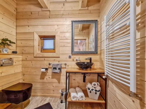 a log cabin bathroom with a sink and a mirror at Kunatówka domek w Zębie in Ząb
