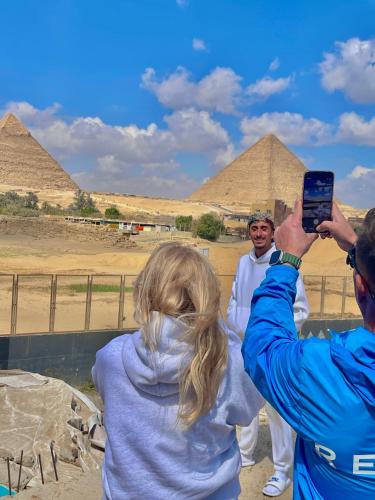 a woman taking a picture of the pyramids at Farida Pyramid Boutique Hotel in Cairo