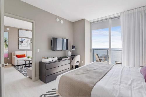 a bedroom with a large bed and a room with a television at Penthouse Ocean Front View Mansion in Sky Corner in Hollywood