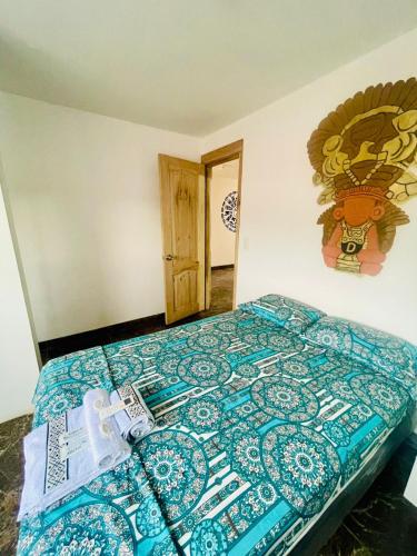 a bedroom with a bed with a blue comforter at Dulce & Guanábana suite House in Canoa
