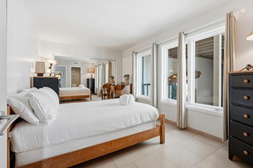 a bedroom with a large bed and a living room at Oceanfront 3BR Condo, Balcony, Fire Pit, Shared Beach, Sleeps 6 in Oceanside
