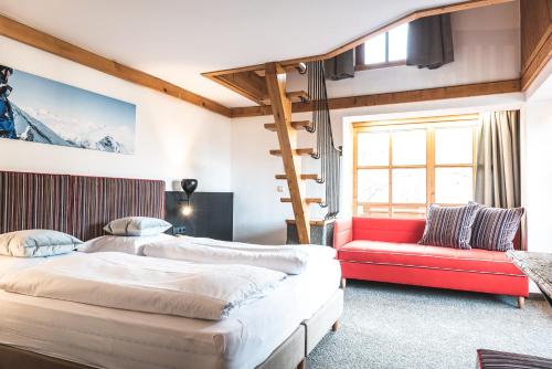 a bedroom with two beds and a red couch at CORE Kaprun in Kaprun