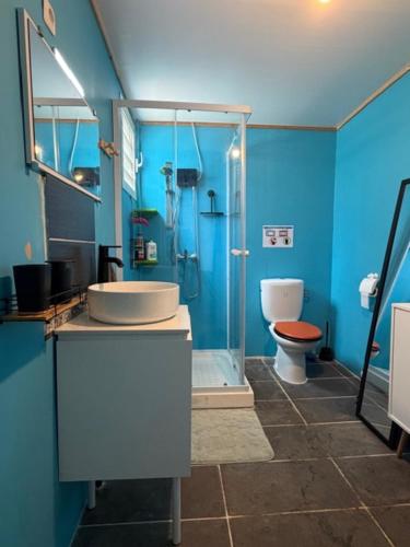 a blue bathroom with a sink and a toilet at Kaz a Ma-Lu in Le Marin