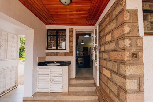 a kitchen with a counter next to a brick wall at Karen Crown 5BR Villa in Nairobi