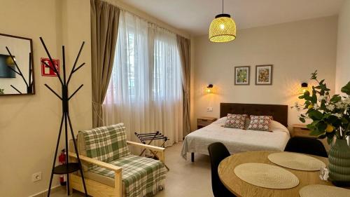 a hotel room with a bed and a table and chairs at Canoa Studio Vlc & Free filtered drinking water in Valencia
