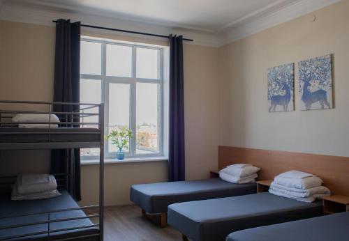 a bedroom with two bunk beds and a window at Stoties Hostelis in Vilnius