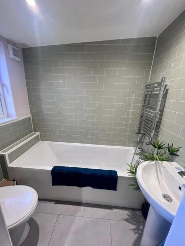 a bathroom with a tub and a toilet and a sink at 2 Swinton Mill Farm Cottage in Swinton