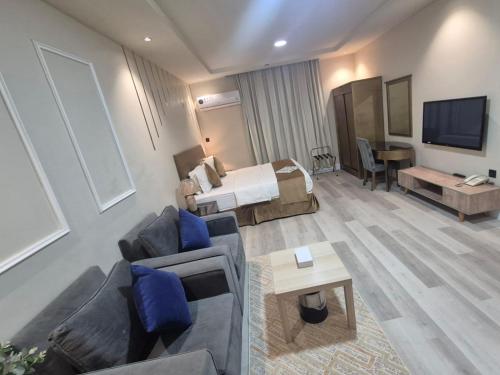 a hotel room with a bed and a living room at درة رواق للشقق المخدومة - Durrat Rwaq Serviced Apartments in Riyadh