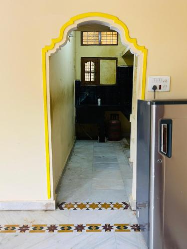 an open door into a room with a kitchen at Pavani staycation in Medchal