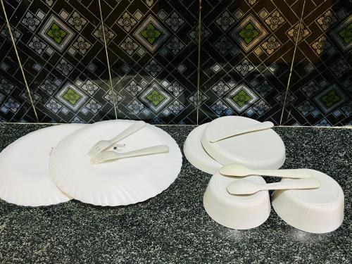 two white plates sitting on top of a counter at Pavani staycation in Medchal